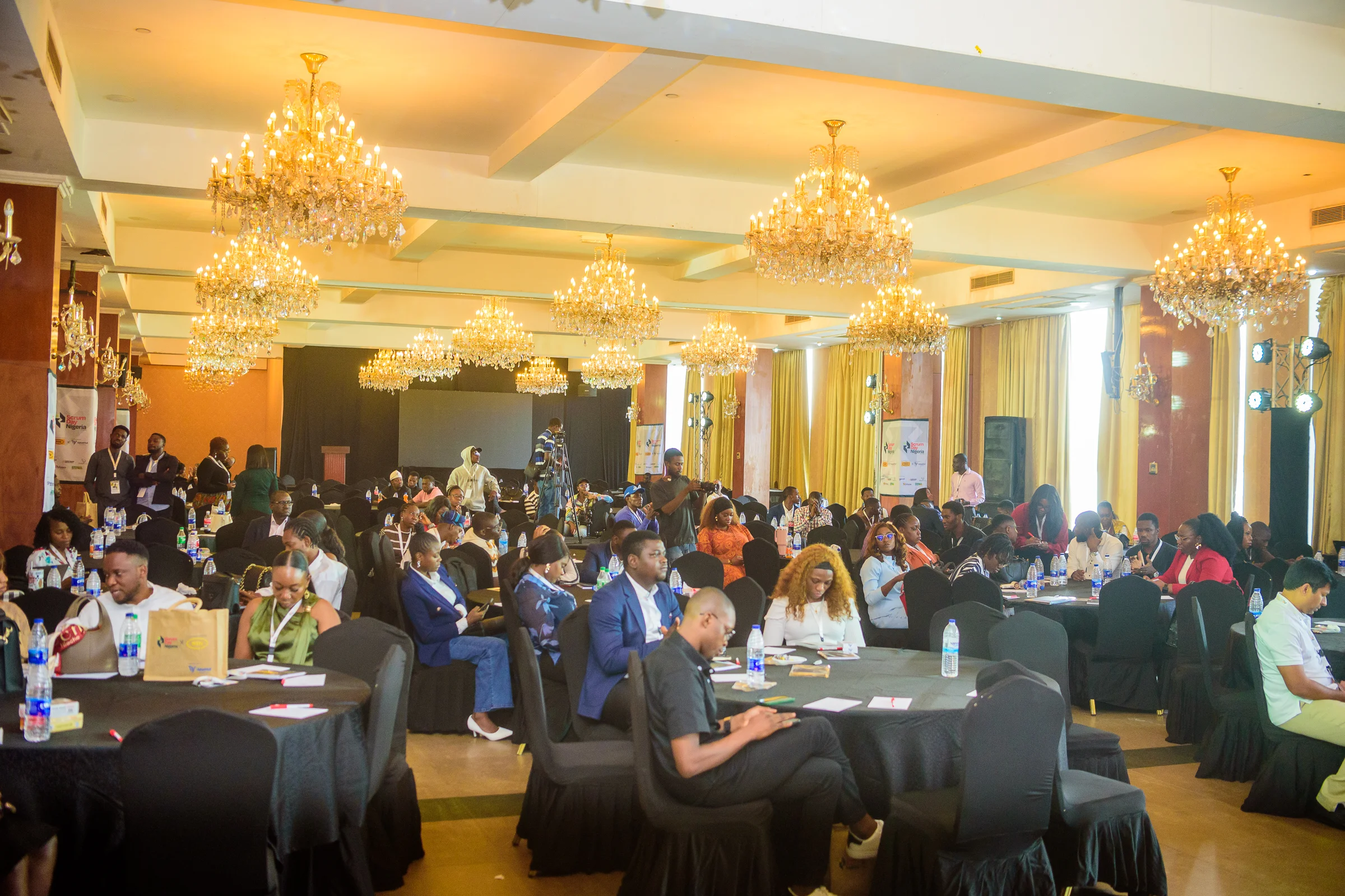 The chandeliered conference ballroom filled with attendees at round tables